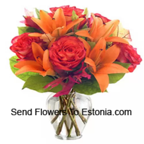 Orangen Lilien und orangefarbene Rosen mit saisonalen Füllern wunderschön in einer Glasvase arrangiert
