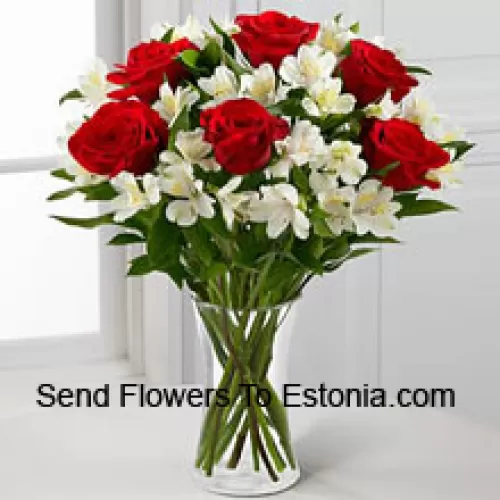 Sette rose rosse con fiori bianchi assortiti e riempitivi in un vaso di vetro